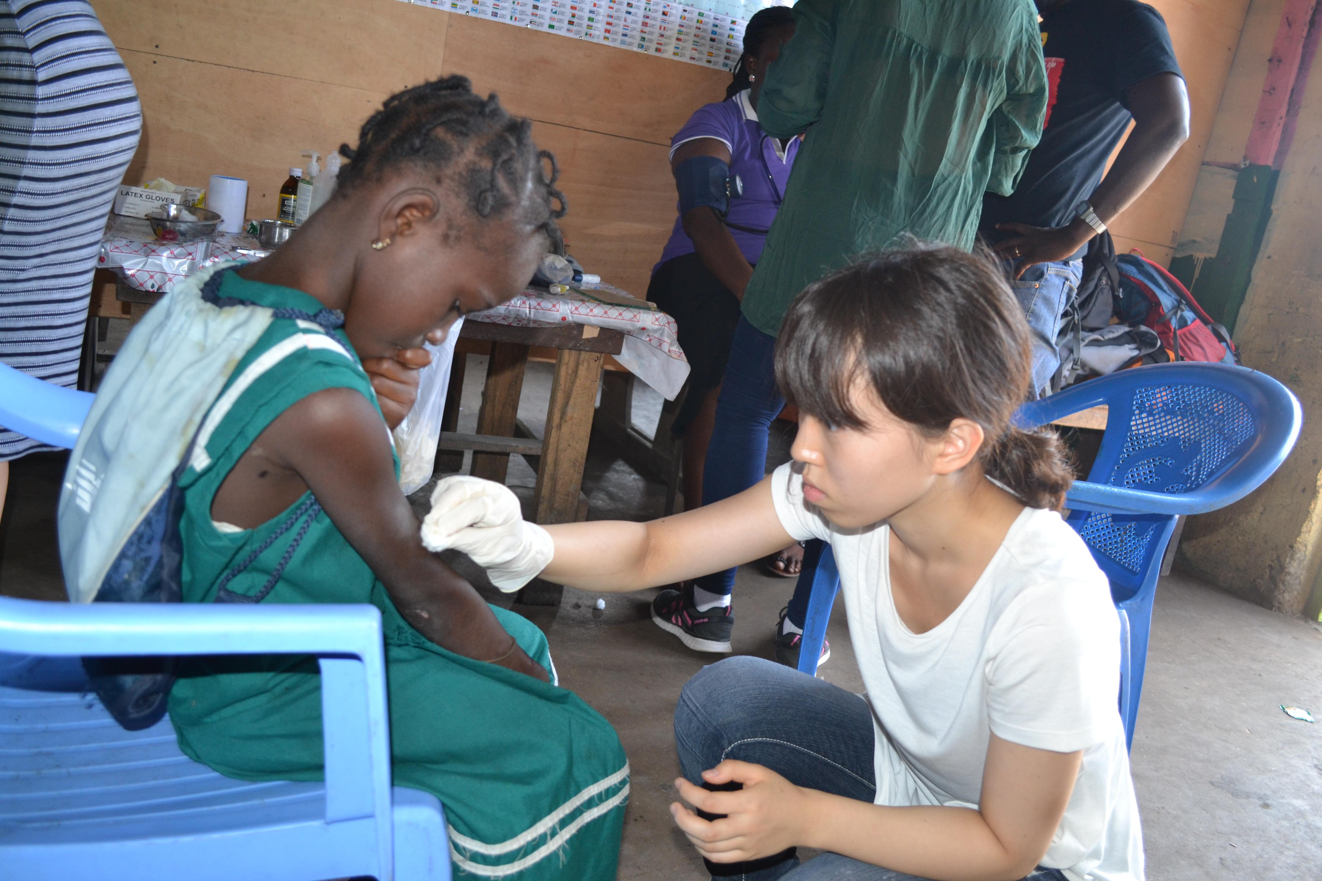 A teenager cleans a child's wound on Projects Abroad's Medical internship in Ghana An intern gains medical work experience cleaning a wound on our project for teenagers in Ghana